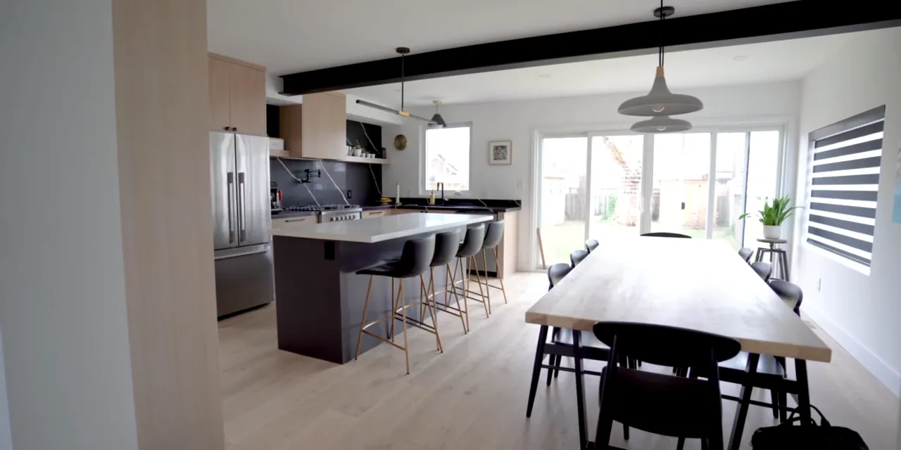 Renovated open-concept kitchen and dining room with a large island, bar stools and a long dining table